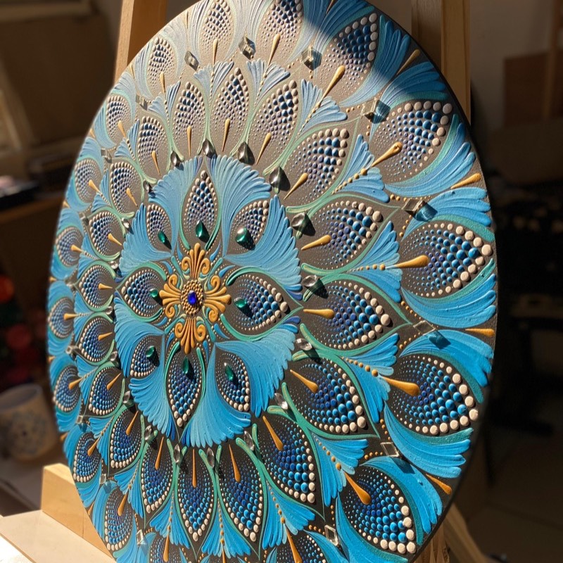 Mandala redonda em pontilhismo azul e turquesa com cristais e centro dourado