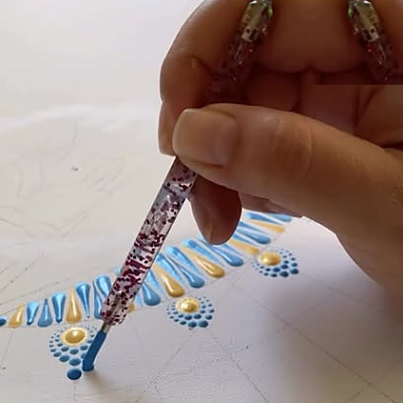Thays Oliveira pintando uma mandala ponto a ponto durante o processo de criação